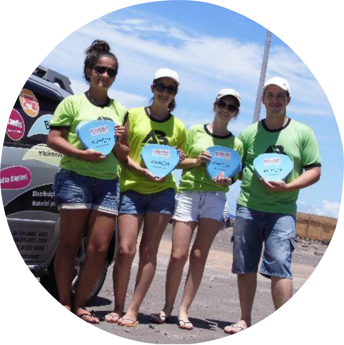 Equipe da ação Kumon com leques promocionais na praia